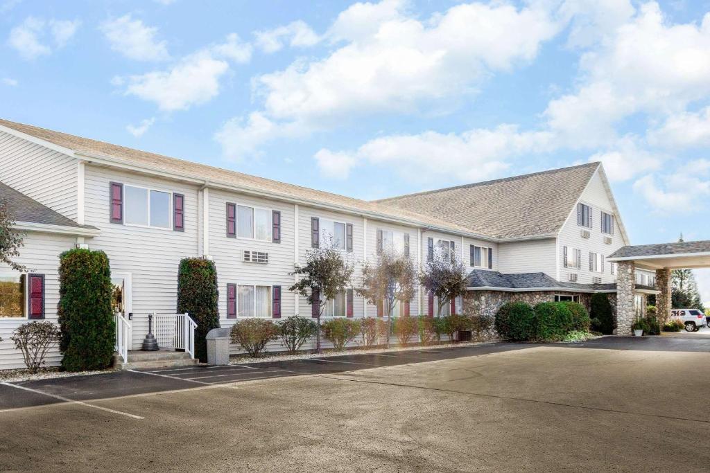 a large white building with a parking lot at Super 8 by Wyndham St. Ignace in Saint Ignace