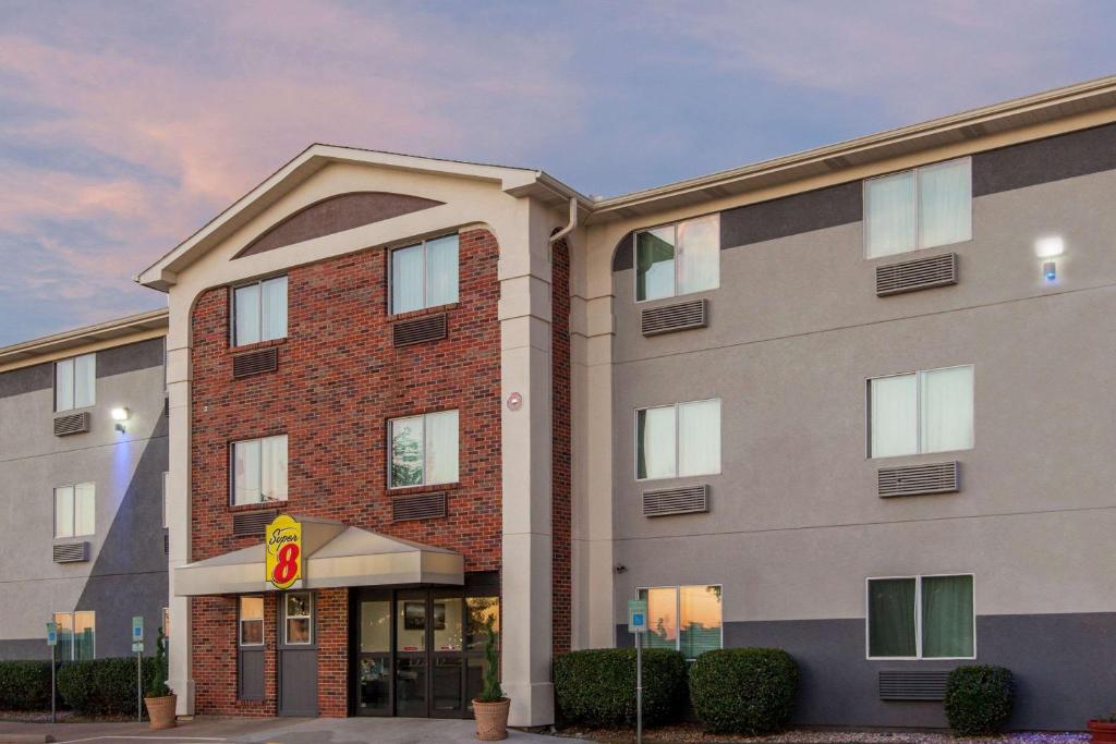 a large brick building with a large window at Super 8 by Wyndham Bedford DFW Airport West in Bedford