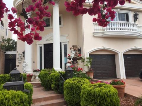 Entire Second Flr - Santa Monica Luxury Roman Villa في لوس أنجلوس: منزل أمامه باقة ورد