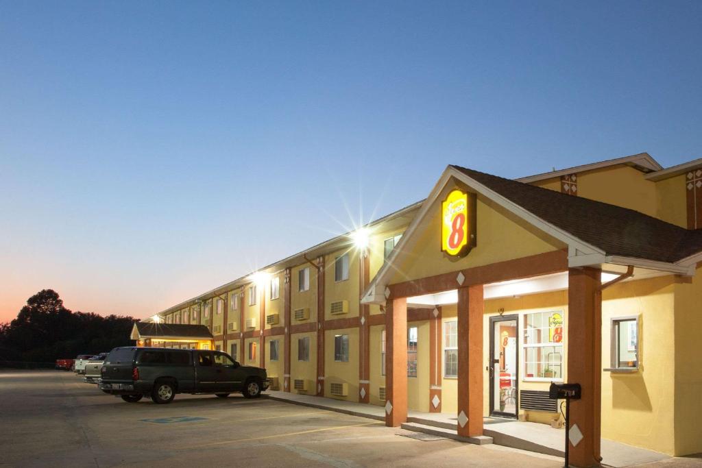 a building with a car parked in front of it at Super 8 by Wyndham Chickasha in Chickasha