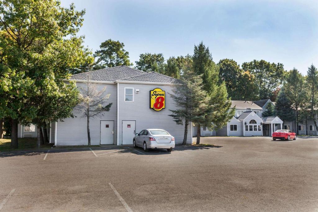 a building with a car parked in a parking lot at Super 8 by Wyndham Schenectady/Albany Area in Schenectady