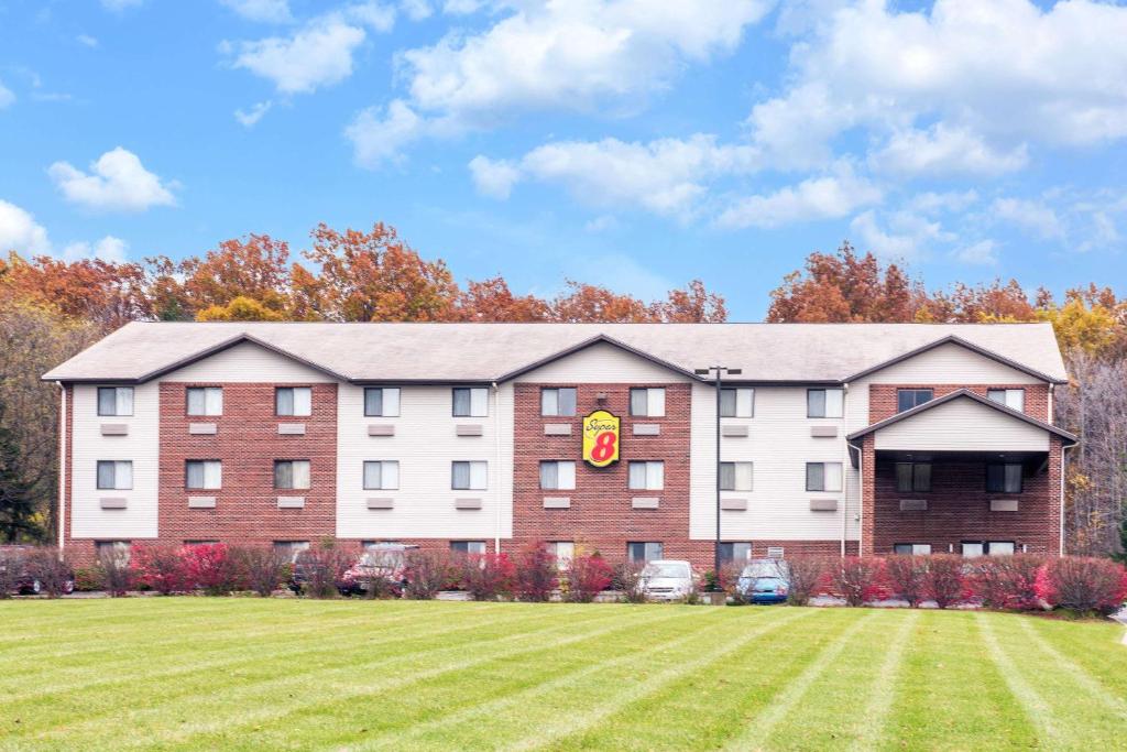 a large building with a lawn in front of it at Super 8 by Wyndham Richfield Cleveland in Richfield