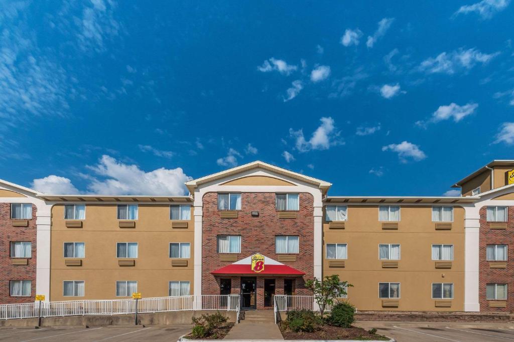 a large building with a red awning at Super 8 by Wyndham Denton in Denton