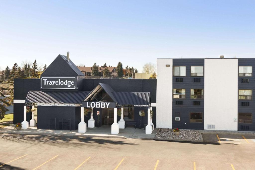 a large building with a sign on the side of it at Travelodge by Wyndham Edmonton South in Edmonton
