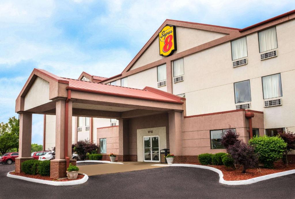 a hotel building with a sign in a parking lot at Super 8 by Wyndham Pevely in Pevely