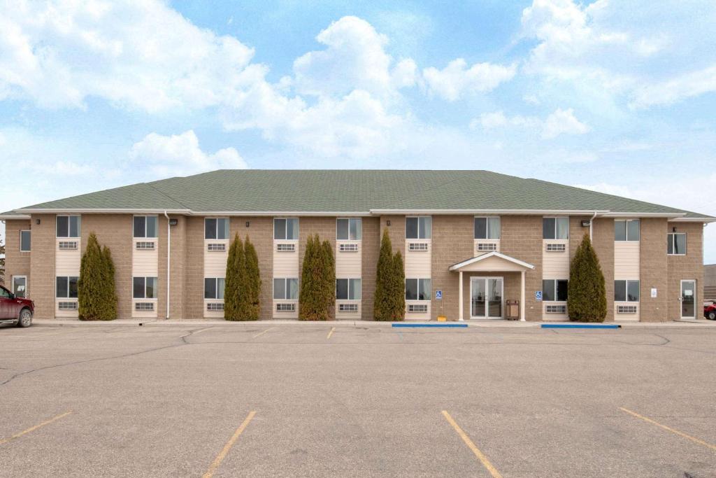 a large tan building with a green roof at Four Seasons Inn in Bottineau