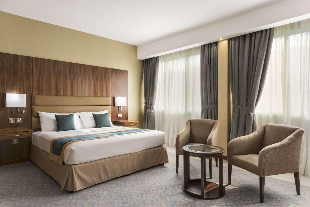 a hotel room with a bed and a chair at Howard Johnson by Wyndham Abu Dhabi Downtown in Abu Dhabi