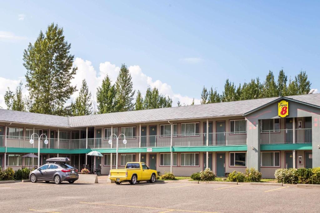 ein Hotel mit Autos auf einem Parkplatz in der Unterkunft Super 8 by Wyndham Quesnel BC in Quesnel