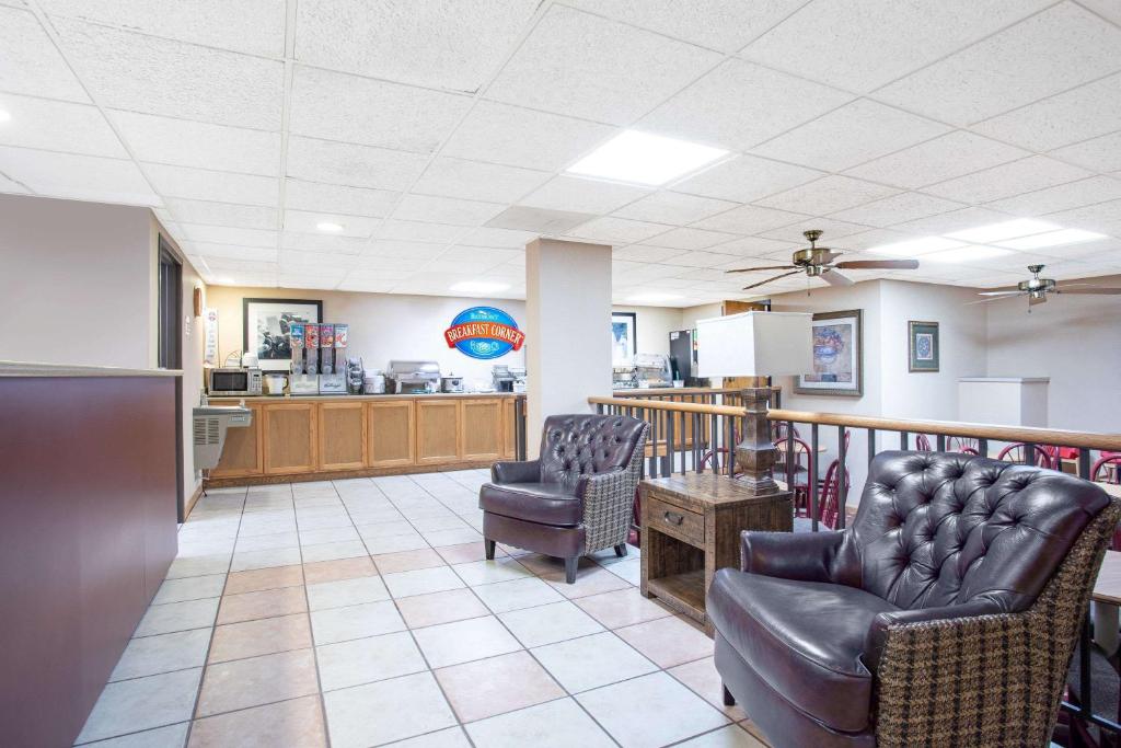 una sala de espera con sillas de cuero y una cocina en Baymont by Wyndham Hays, en Hays