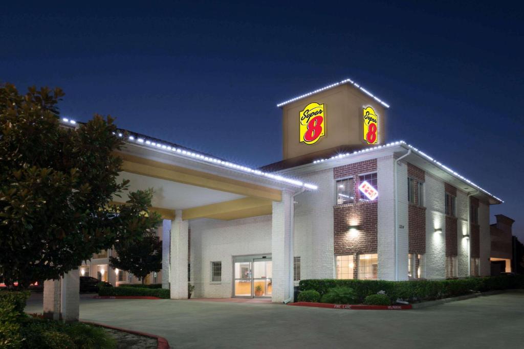 Um edifício com um sinal do McDonald's em cima. em Super 8 by Wyndham Rosenberg TX em Rosenberg