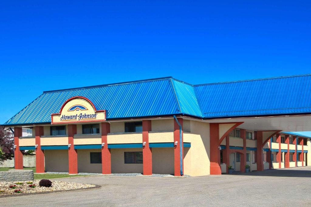 a large building with a blue roof at Howard Johnson by Wyndham Red Deer in Red Deer