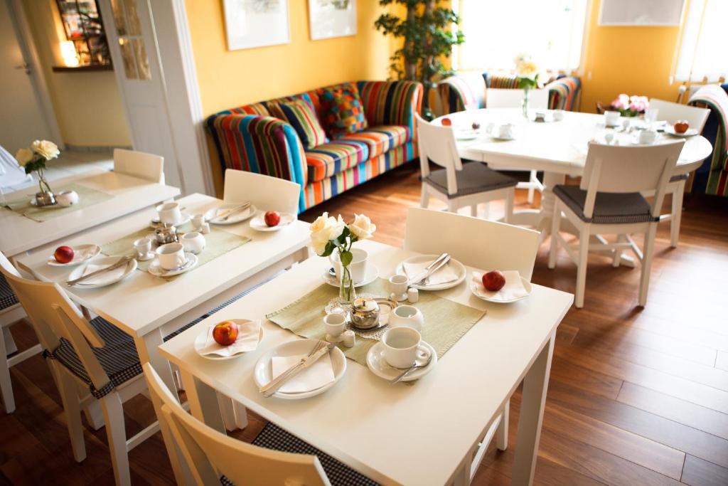 un comedor con mesas y sillas blancas en Landhotel Zum Pottkuchen, en Kalbe