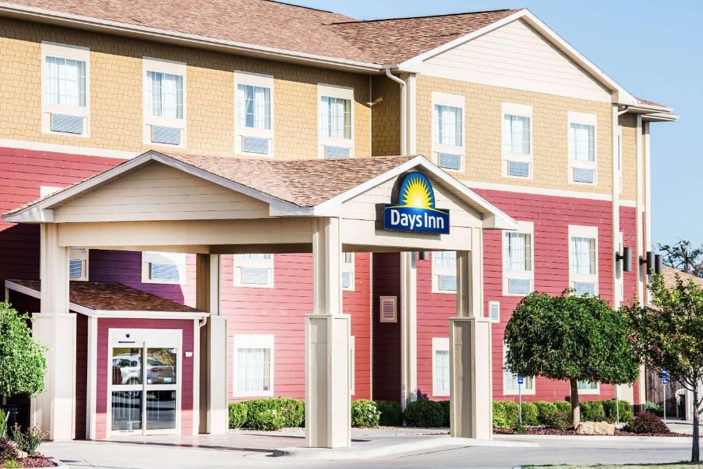 a large red building with a sign that reads daylin at Days Inn by Wyndham Ellis in Ellis