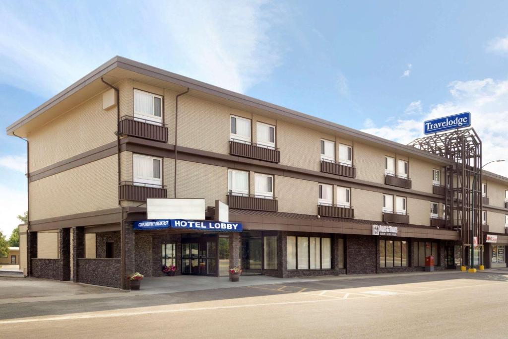 a hotel building on the corner of a street at Travelodge by Wyndham Lethbridge in Lethbridge