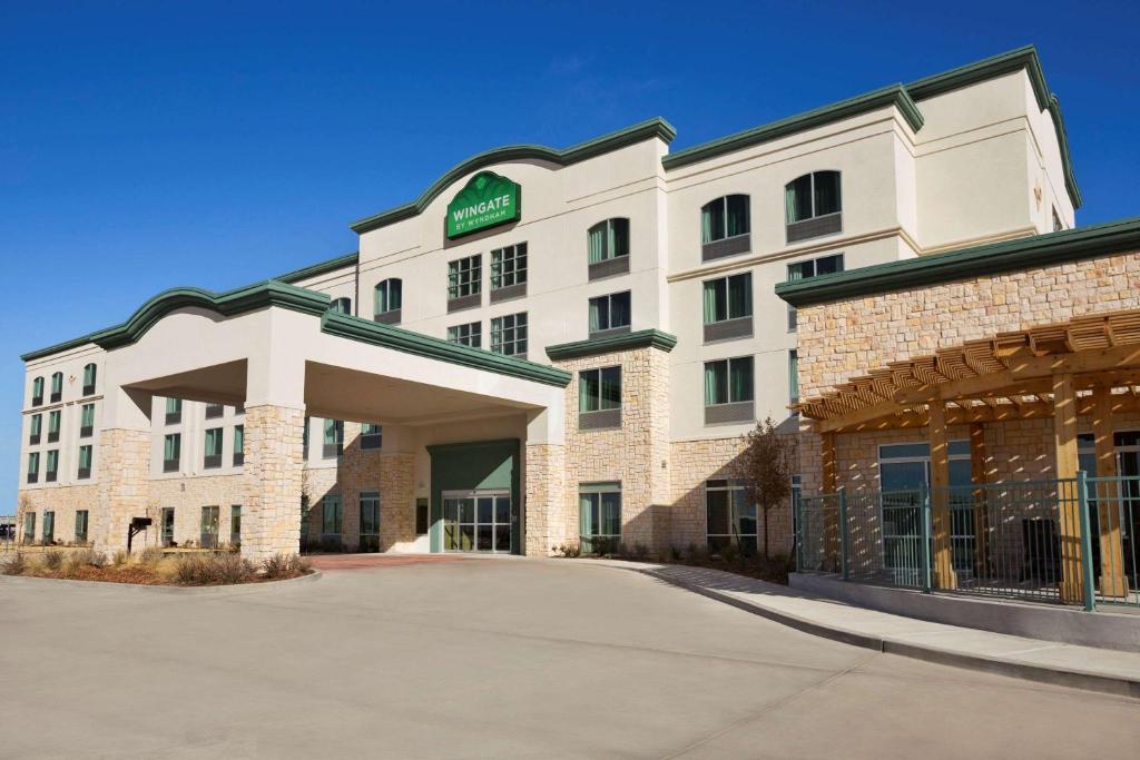 a hotel building with a parking lot in front of it at Wingate by Wyndham Seminole in Seminole