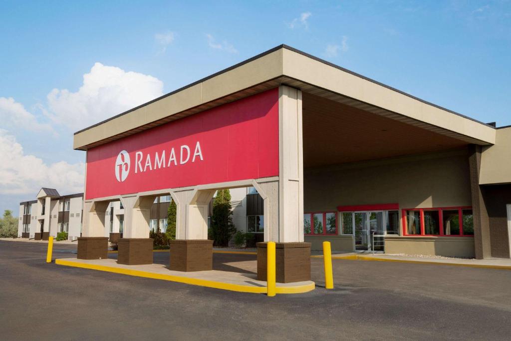 a building with a red sign on the side of it at Ramada by Wyndham Bismarck in Bismarck