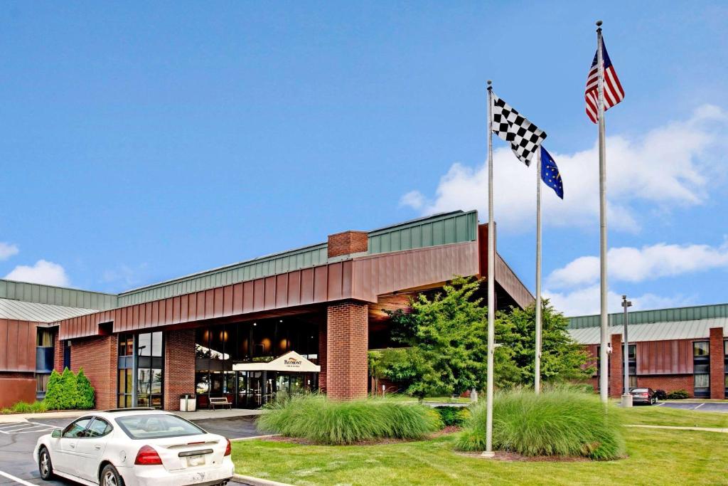 a car parked in front of a building with an american flag at Baymont by Wyndham Indianapolis West in Indianapolis