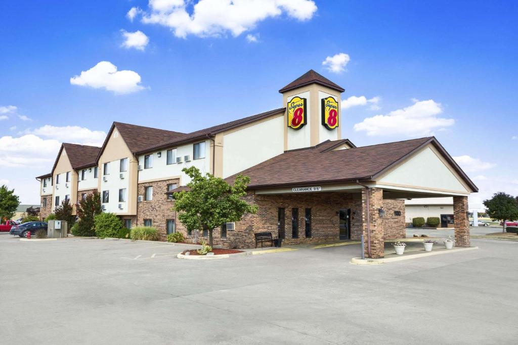 un gran edificio con una torre de reloj en un aparcamiento en Super 8 by Wyndham Carbondale en Carbondale