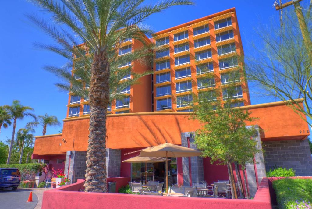 a large palm tree in front of a large building at Ramada by Wyndham Phoenix Midtown in Phoenix