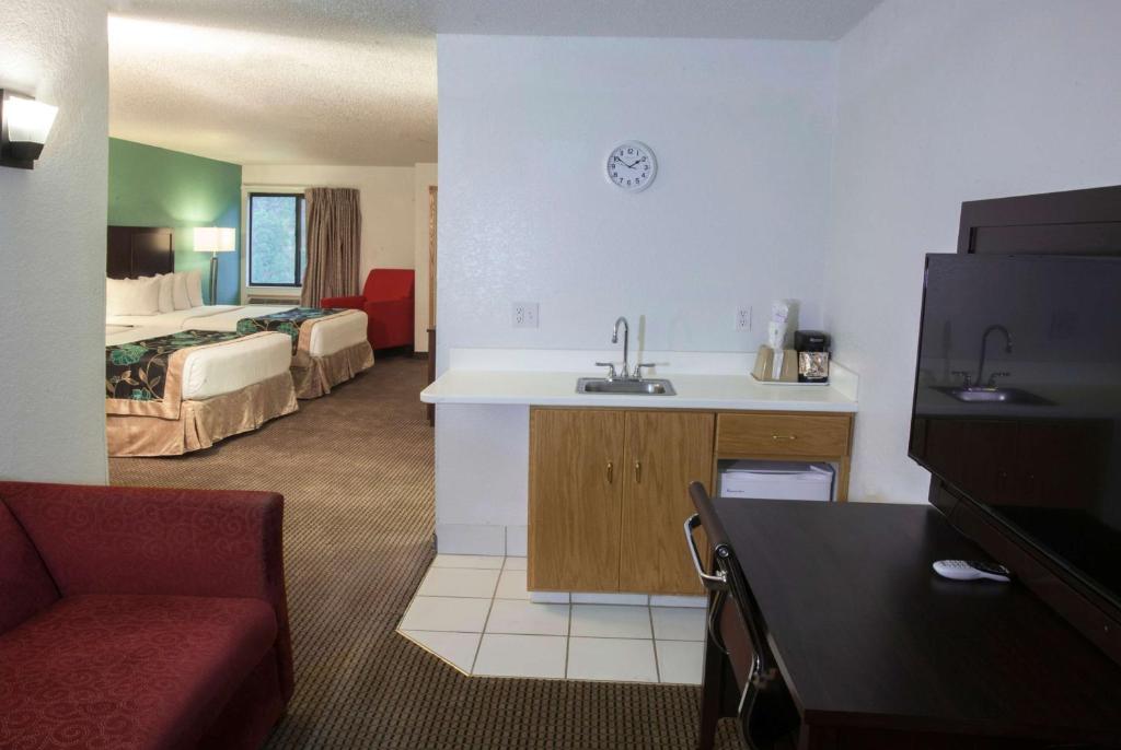 a hotel room with a sink and a room with a bed at Baymont by Wyndham Keystone Near Mt. Rushmore in Keystone