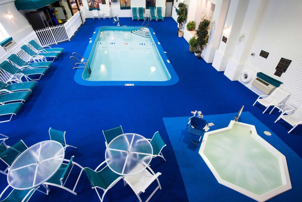 a swimming pool with chairs and a blue floor at Baymont by Wyndham Keystone Near Mt. Rushmore in Keystone