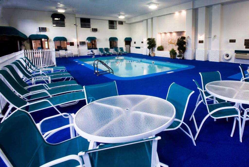 a swimming pool with blue chairs and a table at Baymont by Wyndham Keystone Near Mt. Rushmore in Keystone