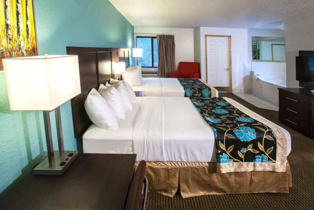 a hotel room with two beds and a table with a lamp at Baymont by Wyndham Keystone Near Mt. Rushmore in Keystone