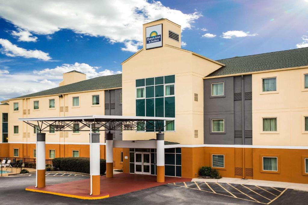 a hotel with a clock tower on top of a building at Days Inn & Suites by Wyndham Augusta Near Fort Eisenhower in Augusta