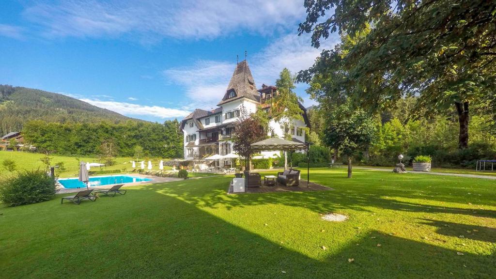 uma grande casa com um grande quintal com uma piscina em Landhaus Koller em Gosau