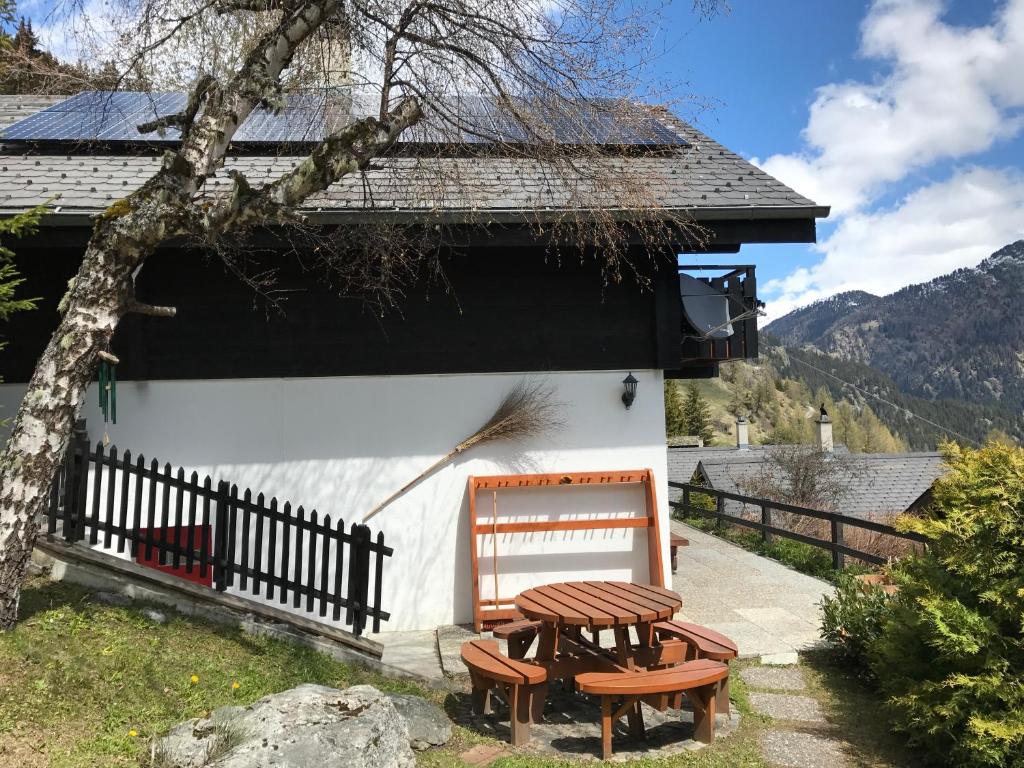 a house with a bench and a table and a chair at Tschuggen 61 in Blatten bei Naters