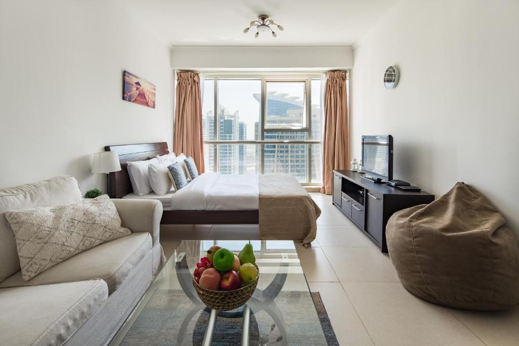uma sala de estar com um sofá e uma cama em Frank Porter - Goldcrest Executive em Dubai