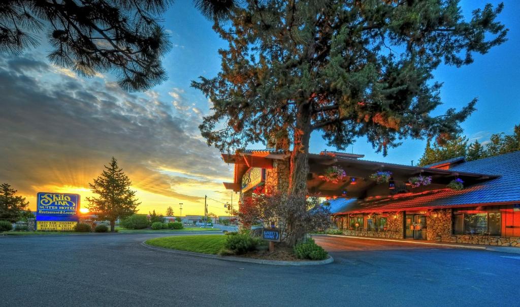 un edificio con un árbol delante de él en Shilo Inn Suites Hotel - Bend, en Bend