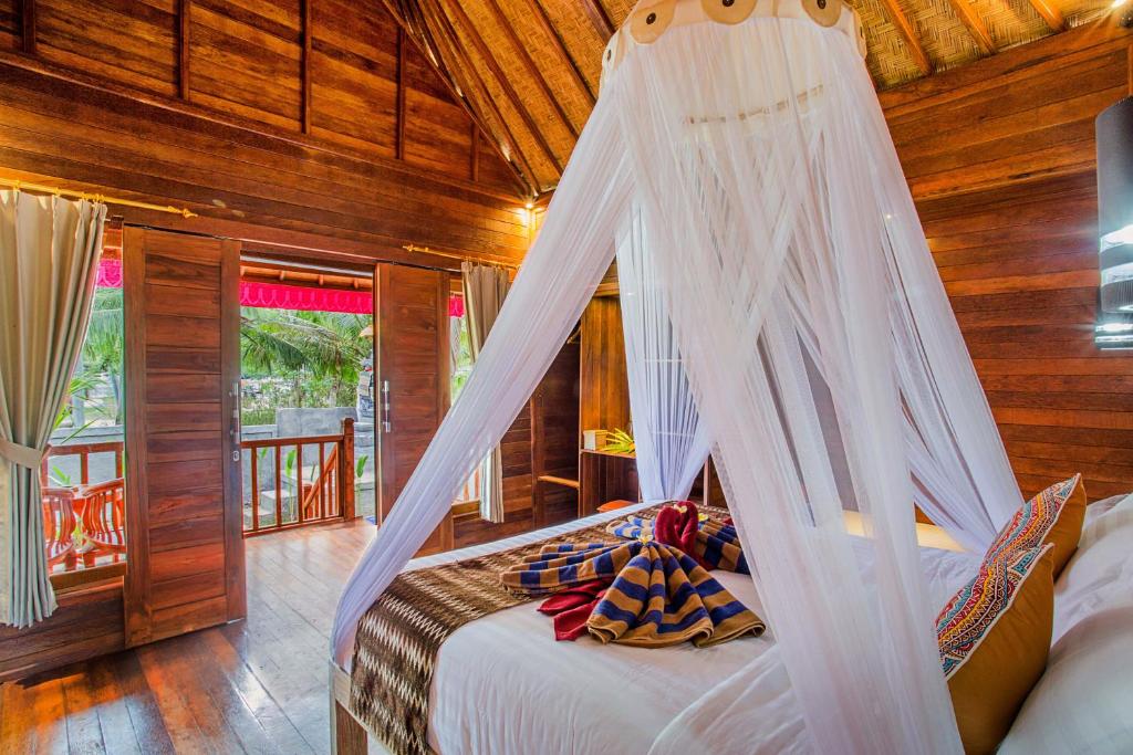 a bedroom with a bed with a mosquito net at Sea Bridge Villa Ceningan in Nusa Lembongan
