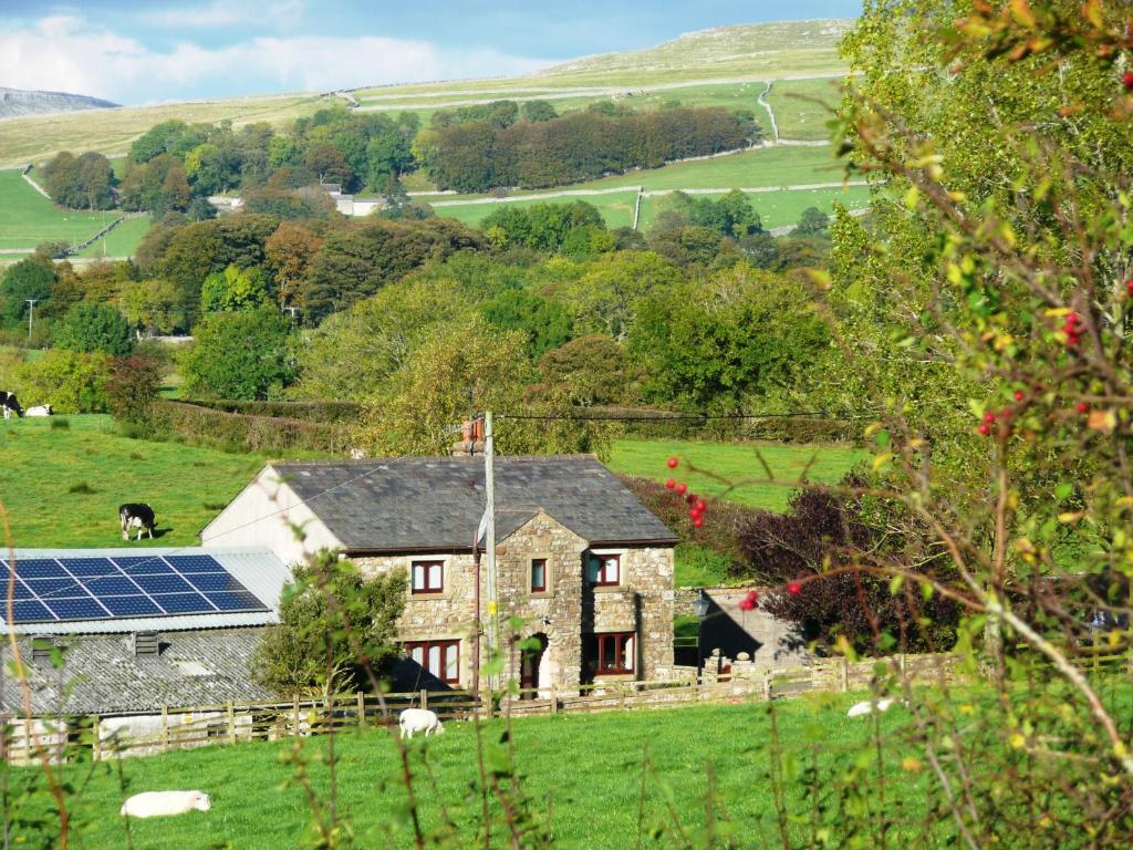 une maison avec un panneau solaire dans un champ dans l'établissement Nutstile Farm Bed and Breakfast, à Ingleton