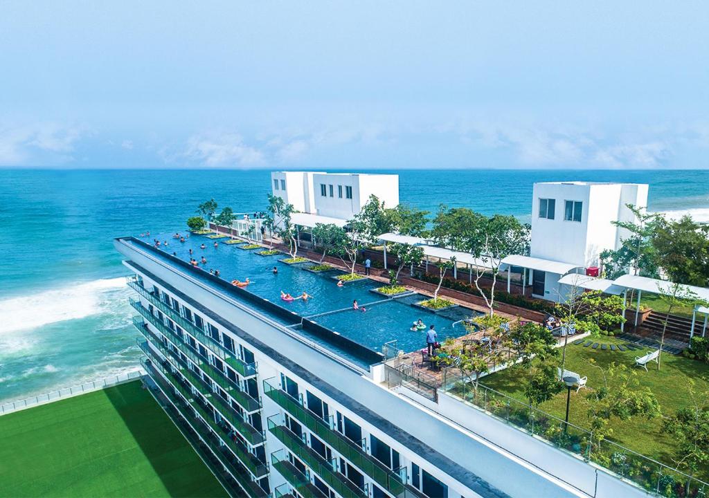 a building with a swimming pool next to the ocean at Marino Beach Colombo in Colombo