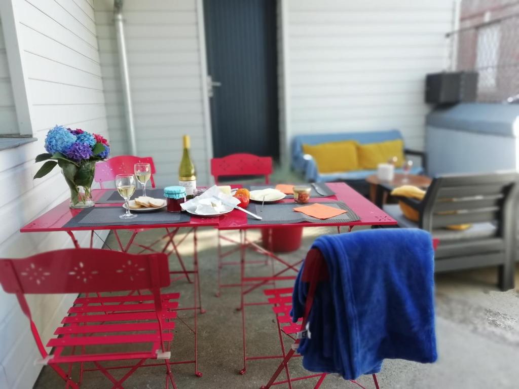 オンフルールにあるLe charme à la Françaiseのテーブル(赤い椅子付)とテーブル(食べ物付)