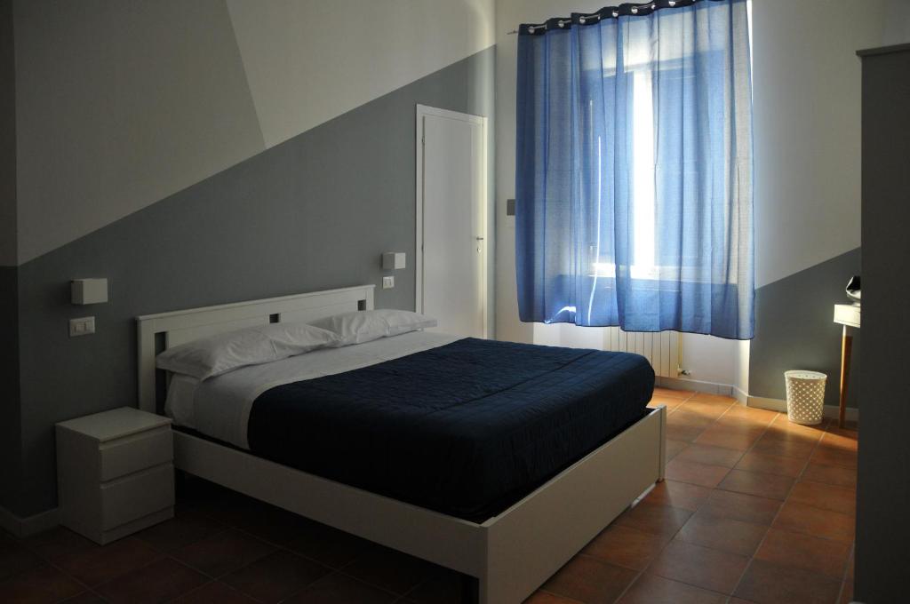 um quarto com uma cama com um cobertor azul e uma janela em Le Pignattelle B&B em Siena