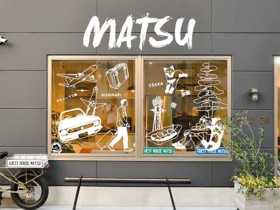 Guest House Matsu في أوساكا: علامة الميتزفه على جانب نافذة متجر