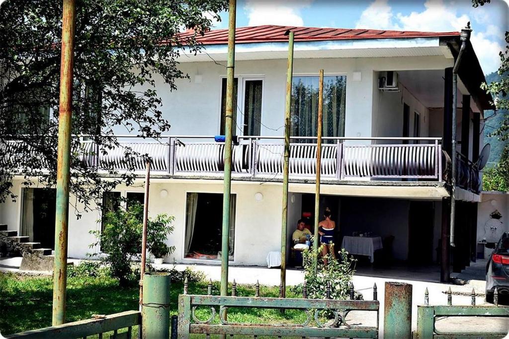 Casa blanca con balcón en la parte superior. en guest house QEDI en Jvari