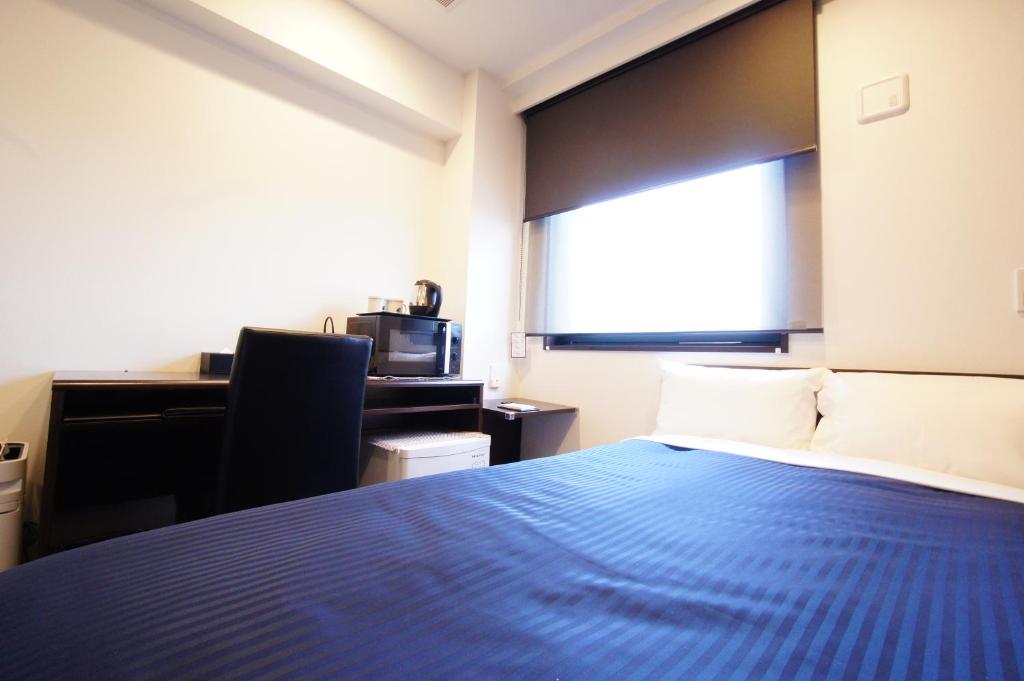 Postel nebo postele na pokoji v ubytování HOTEL LiVEMAX Kanazawa Ekimae