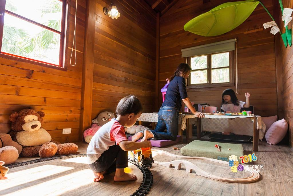 a group of children playing in a room with wooden walls at Sheep House B&amp;B in Ji&#39;an