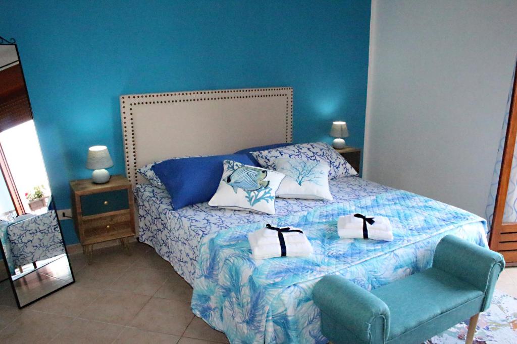 a blue bedroom with a bed and a chair at Piana delle Galee in Scilla