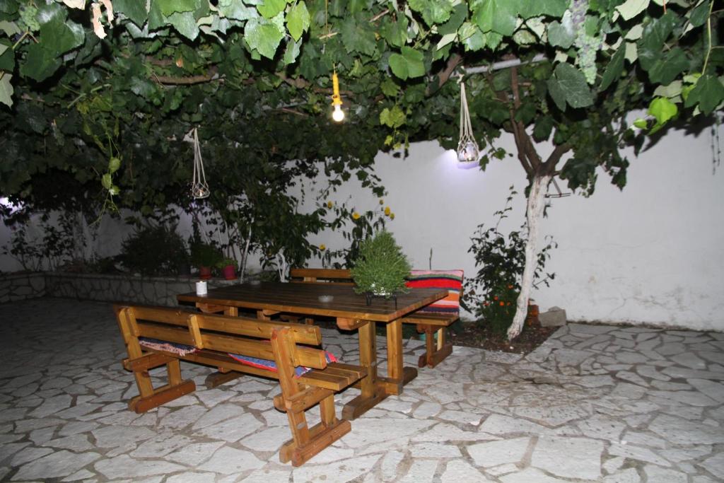 Kondilw Rooms في كالاميتسي: طاولة نزهة ومقعدين تحت شجرة
