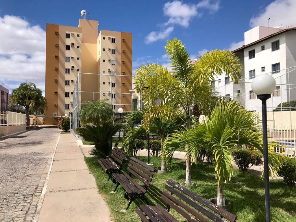 a park with benches and palm trees and buildings at Vale Hospedar Califórnia Apart in Petrolina