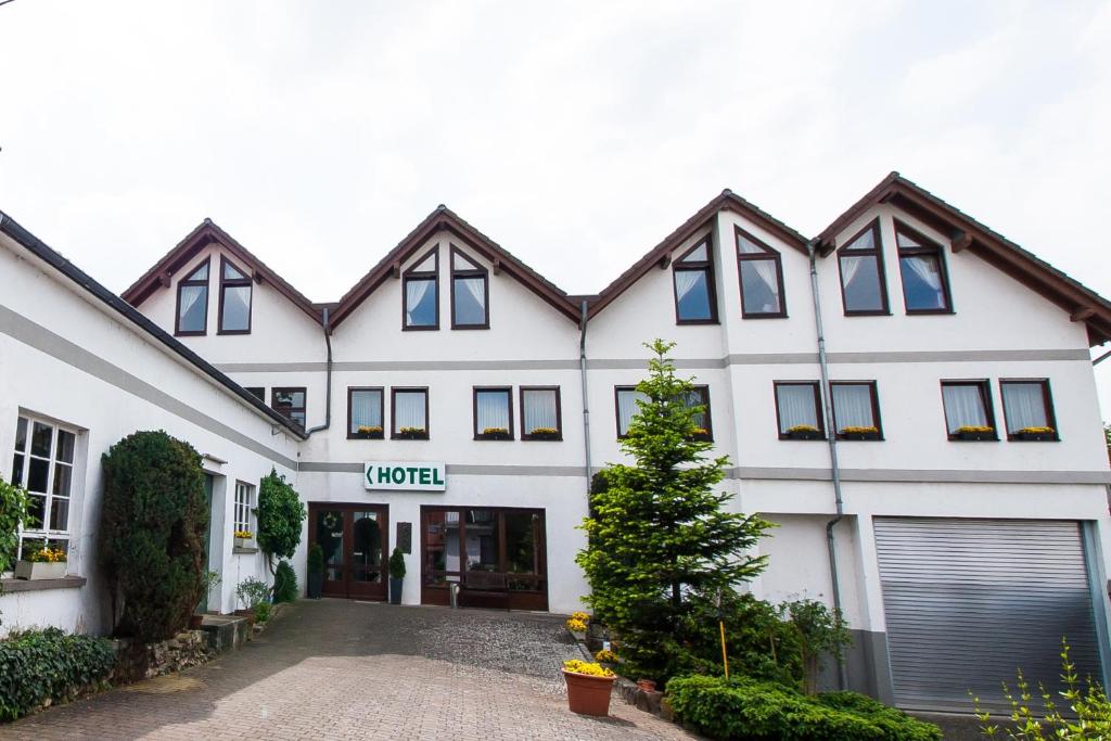 a large white building with a garage at Hotel Janssen in Bodenheim
