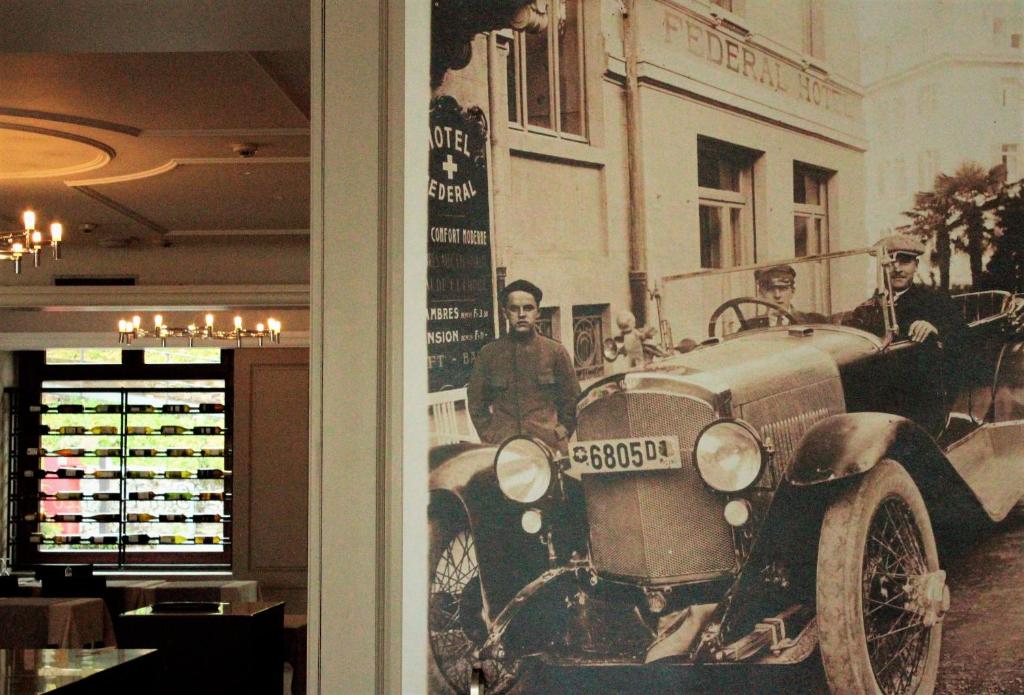 a group of men standing next to an old car at Hotel Federale in Lugano
