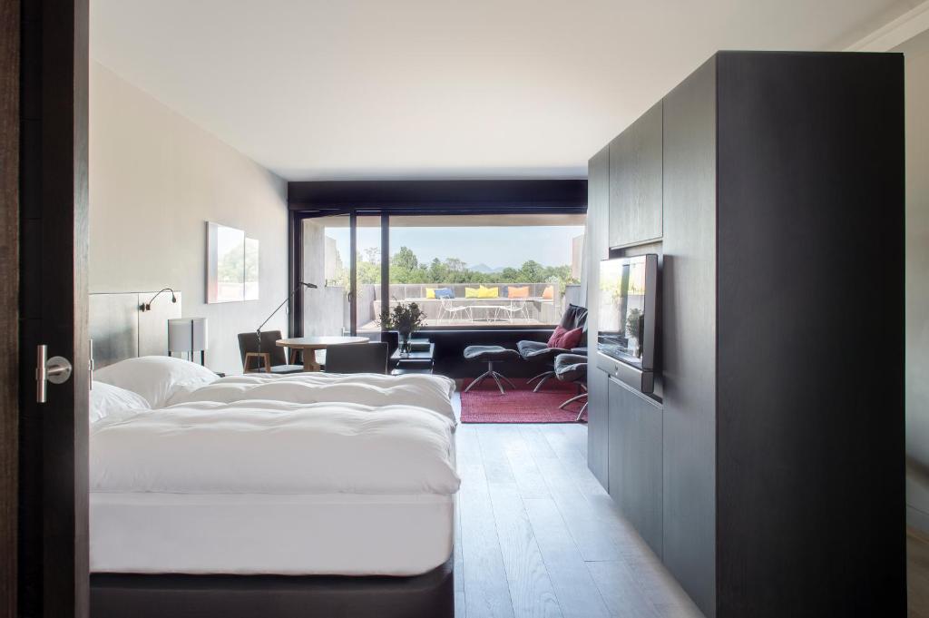 um quarto com uma cama e um quarto com uma janela em Eurostars Pamplona em Pamplona