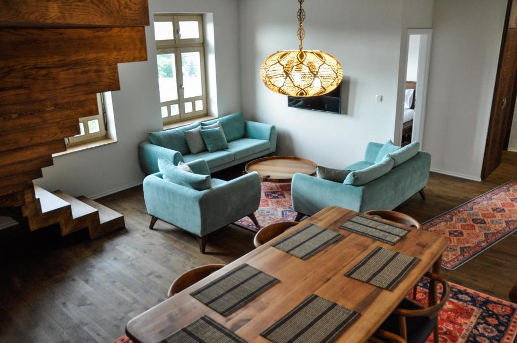 uma sala de estar com mesa e cadeiras em Apartments Salim em Saraievo