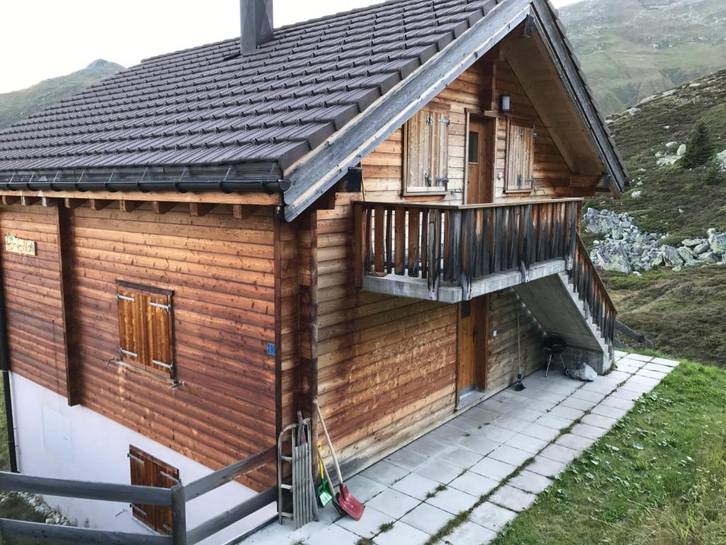 een houten huis met een balkon op een heuvel bij Farfalla in Blatten bei Naters
