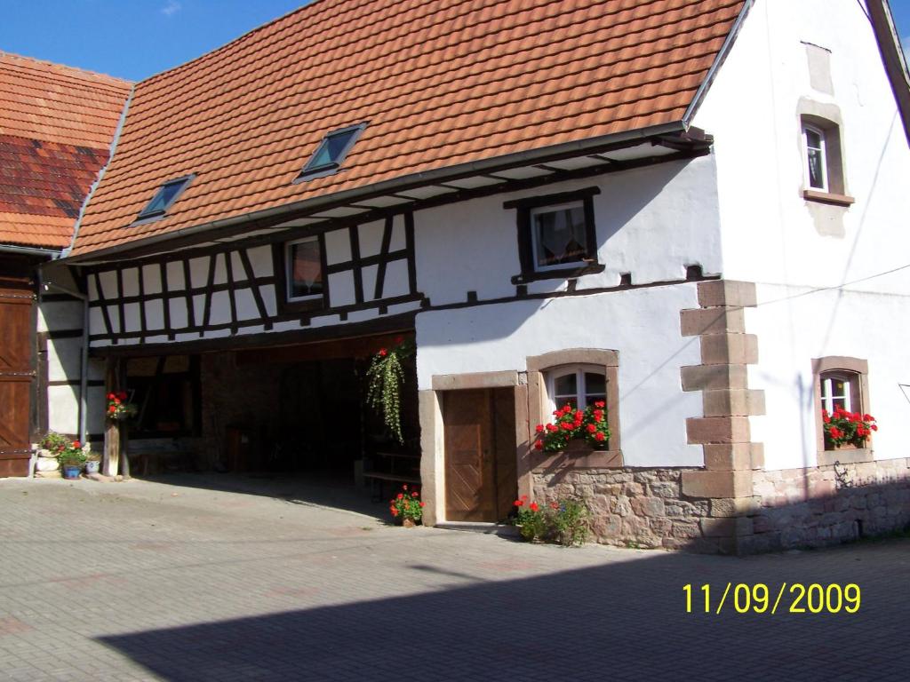 een wit gebouw met een rood dak bij GÎte rue de l'Ange in Hunspach